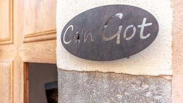 Un cartel de metal con la inscripción 'Can Got' sobre una pared con textura.