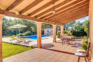 A covered patio with a pool, outdoor furniture, and a view of the surrounding landscape. - In a peaceful location with pool - Camí d'es Torres (portopetro)