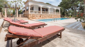 A villa with a swimming pool, sun loungers, and a stone facade. - Luxurious villa with pool - Villa Torre (cala santanyi)