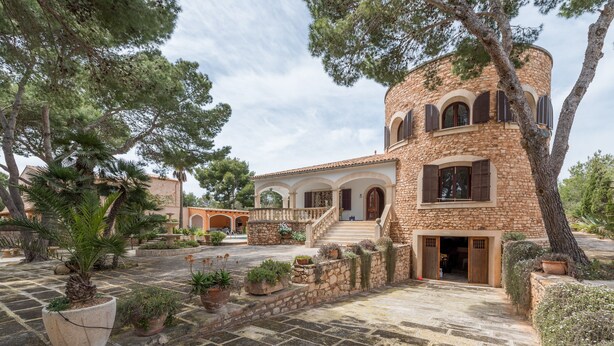 A stone building with a courtyard, a staircase, and potted plants. - Luxurious villa with pool - Villa Torre (cala santanyi)