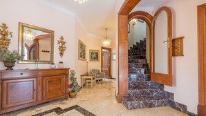 A grand hallway with marble flooring, a wooden staircase, and a large mirror. - Luxurious villa with pool - Villa Torre (cala santanyi)