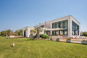 Uma casa moderna de dois andares com varanda, área de estar externa e piscina.