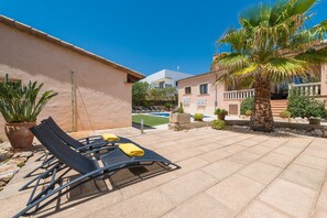 Eine Terrasse mit Liegestühlen und einem Pool.