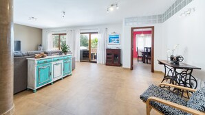 Ein großzügiger Wohnbereich mit Sofa, Schrank, Tisch und Stuhl.