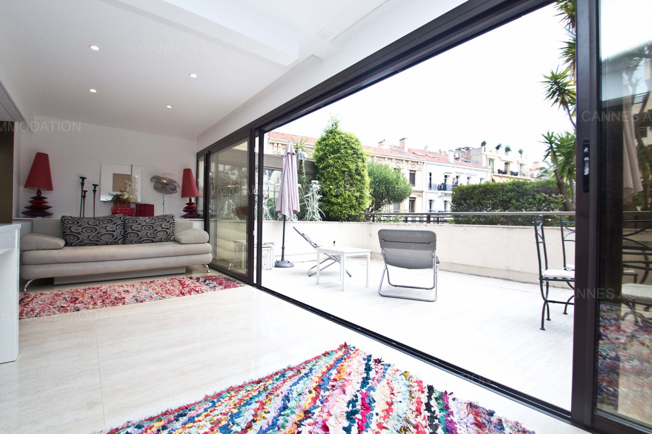 A modern living room with a large sliding glass door leading to a balcony.