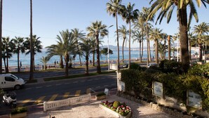 Une route côtière bordée de palmiers, avec une vue sur la mer.