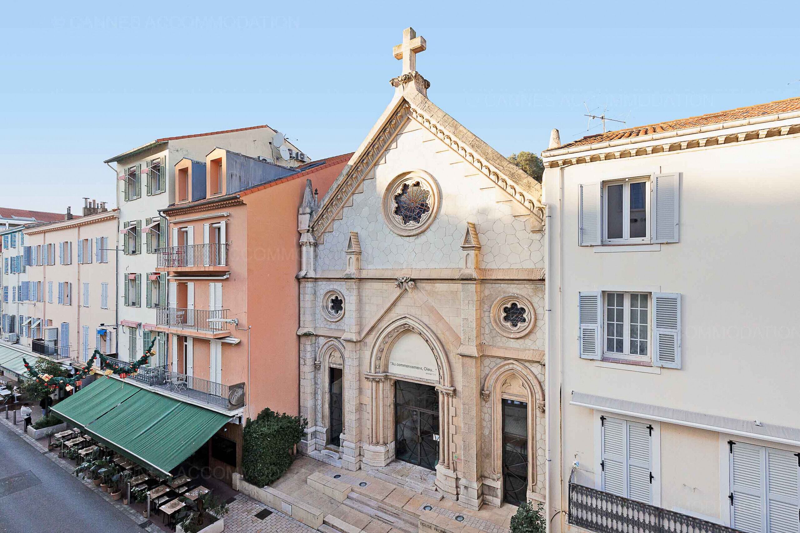 A church with a prominent cross, arched windows, and a bell tower.