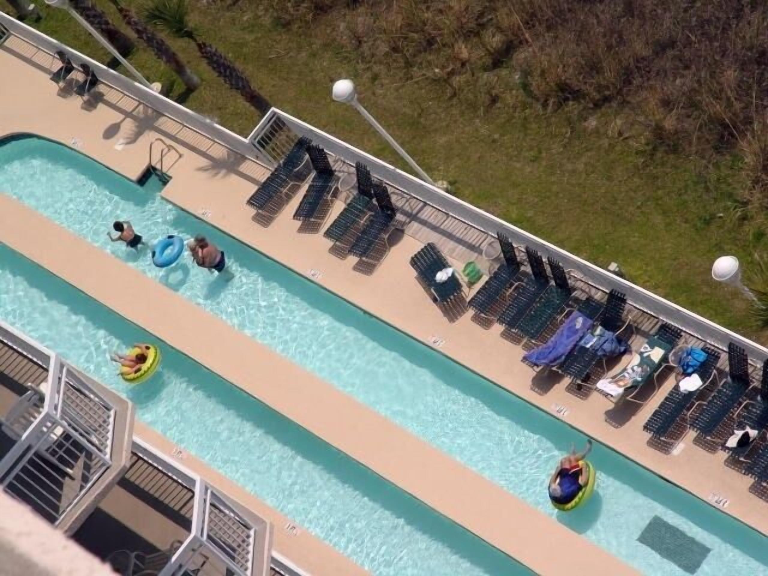 Un espace piscine équipé de chaises longues et d’un toboggan.