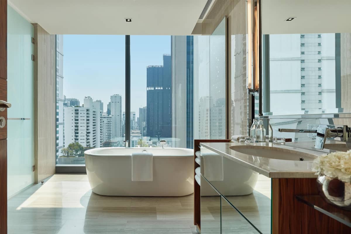 Une salle de bain moderne dotée d’une grande baignoire, d’une douche séparée et d’un meuble-lavabo avec un miroir.