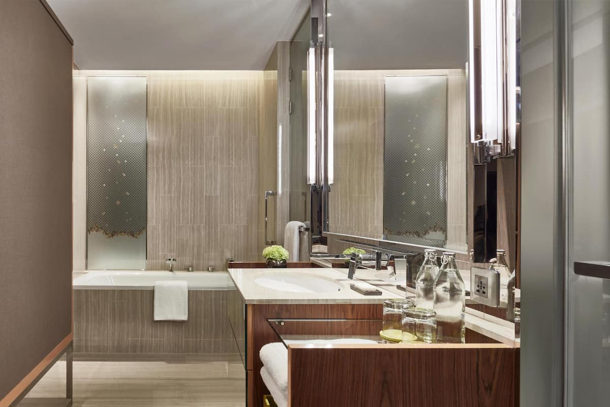 Une salle de bain moderne avec une baignoire, deux lavabos et un grand miroir.