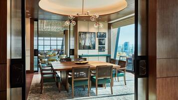 A modern dining area with a wooden table, chairs, and a chandelier.