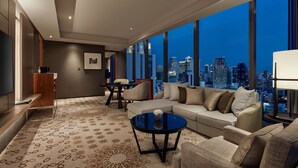 A modern hotel room with a large city view, a sofa, a coffee table, and a dining area. - Hyatt Regency Bangkok Sukhumvit (Bangkok)