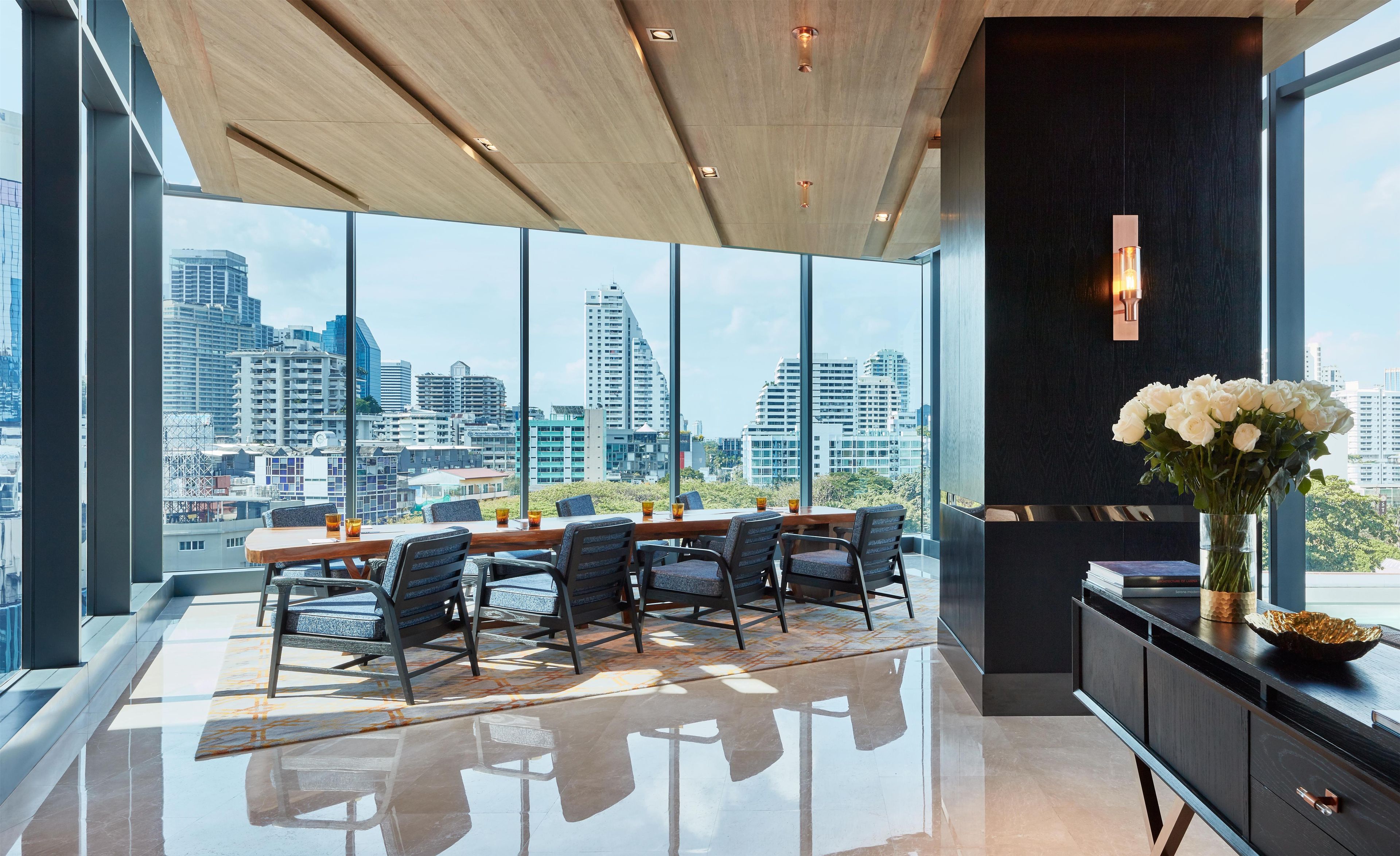 A modern dining area with a city view, large windows, and a polished floor.