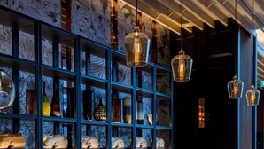 A modern interior with a seating area, shelves with decorative items, and hanging lights.