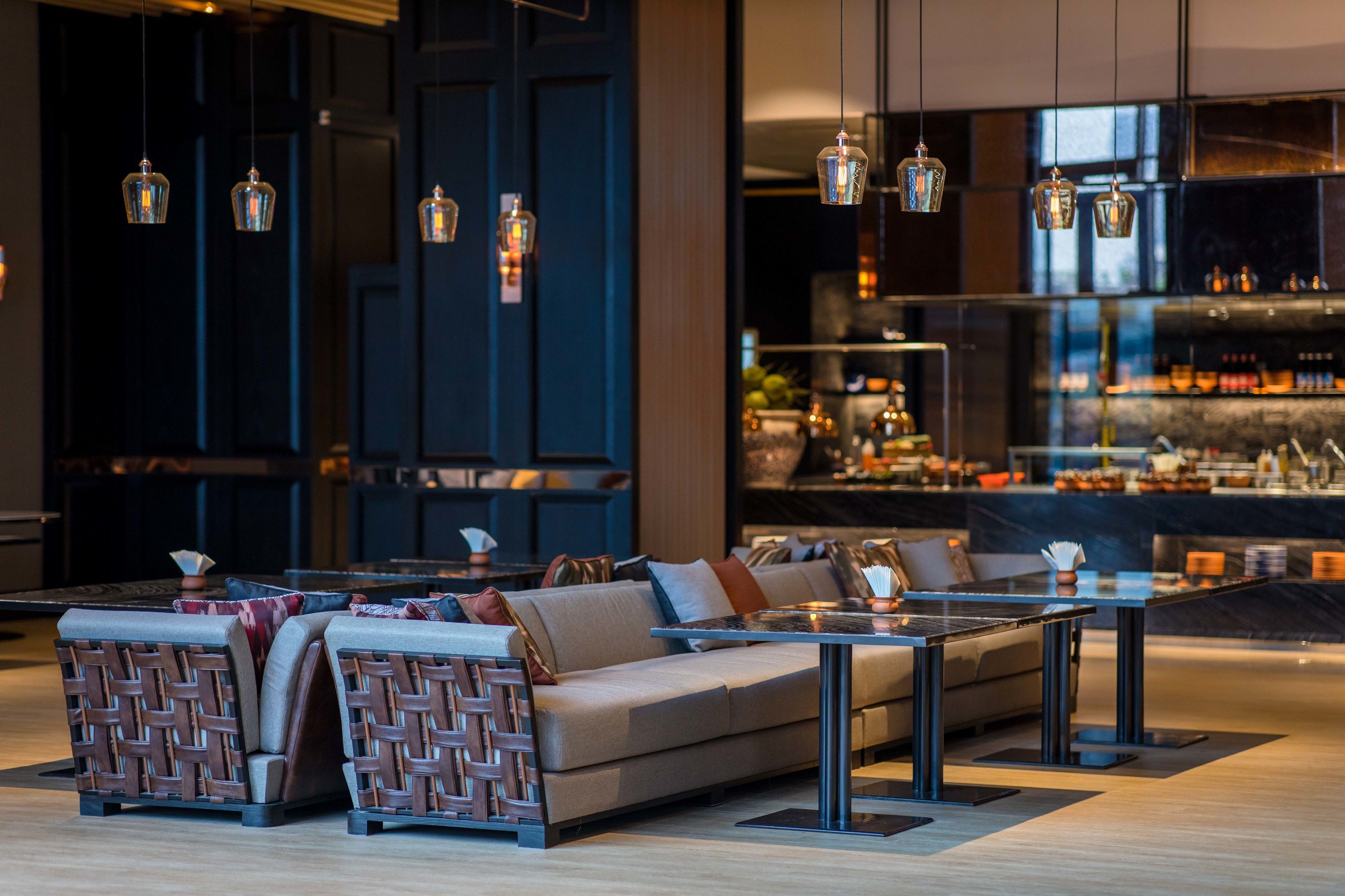 A modern lounge area with a sofa set, a coffee table, and hanging pendant lights.
