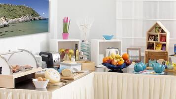 Un buffet de petit-déjeuner proposant une variété d’aliments, un saladier de fruits et une petite bibliothèque.