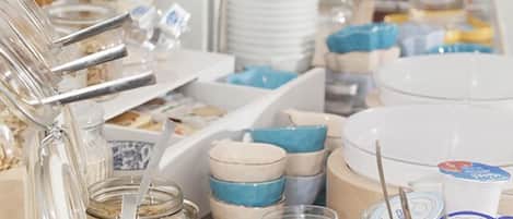 A buffet setup with various food items and serving utensils.