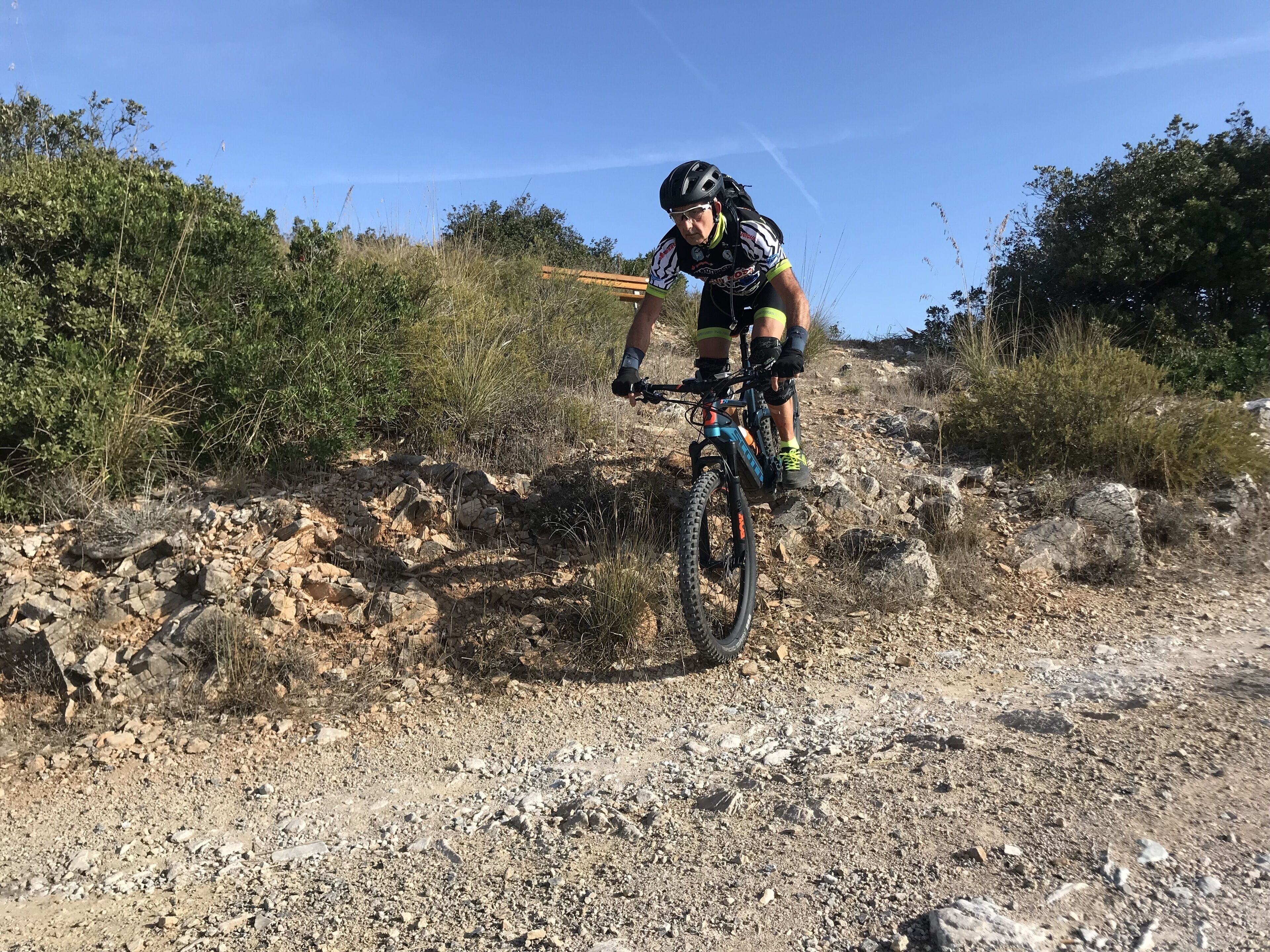 En person cykler på en mountainbike på en stenet sti.