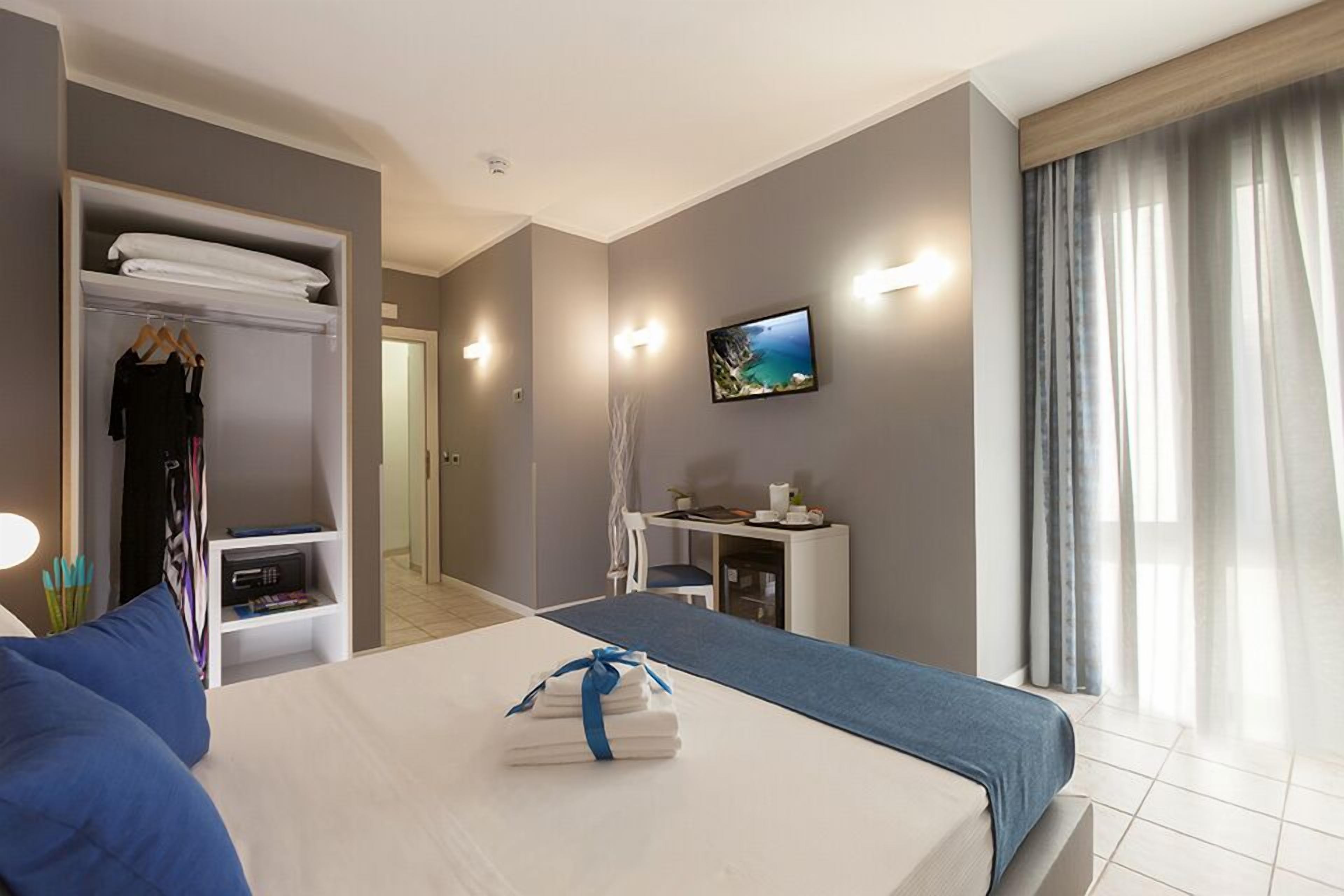 A hotel room with a bed, a TV, a desk, and a wardrobe.