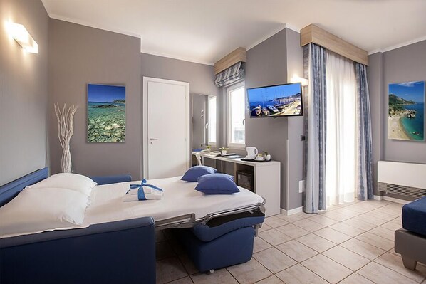 Una habitación de hotel moderna con una cama, un escritorio y un televisor.