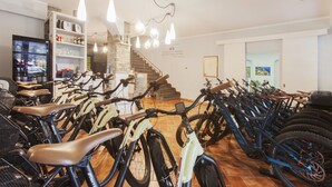 A bike rental shop with multiple bicycles and a staircase leading to a second floor. - Bike&Boat Argentario Hotel (Monte Argentario)