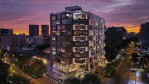 Een modern hotel met meerdere verdiepingen, grote ramen en een goed verlichte gevel.