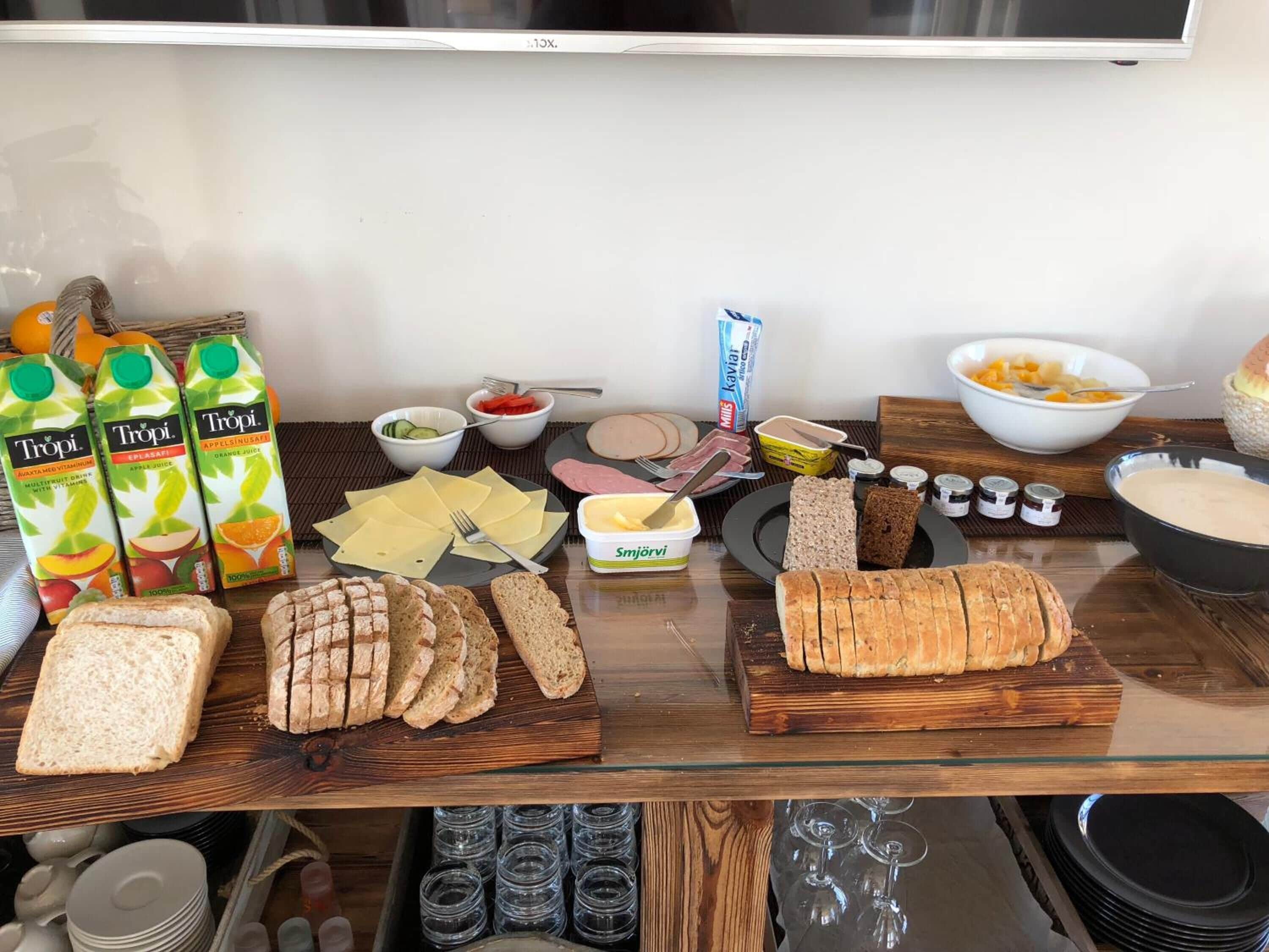 Un tavolo per buffet con diversi cibi, tra cui pane, formaggio e salse.