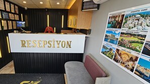 A reception area with a reception desk labeled "RESEPSİYON" and a wall displaying various city landmarks. - Sahrakent Otel Atasehir (Istanbul)