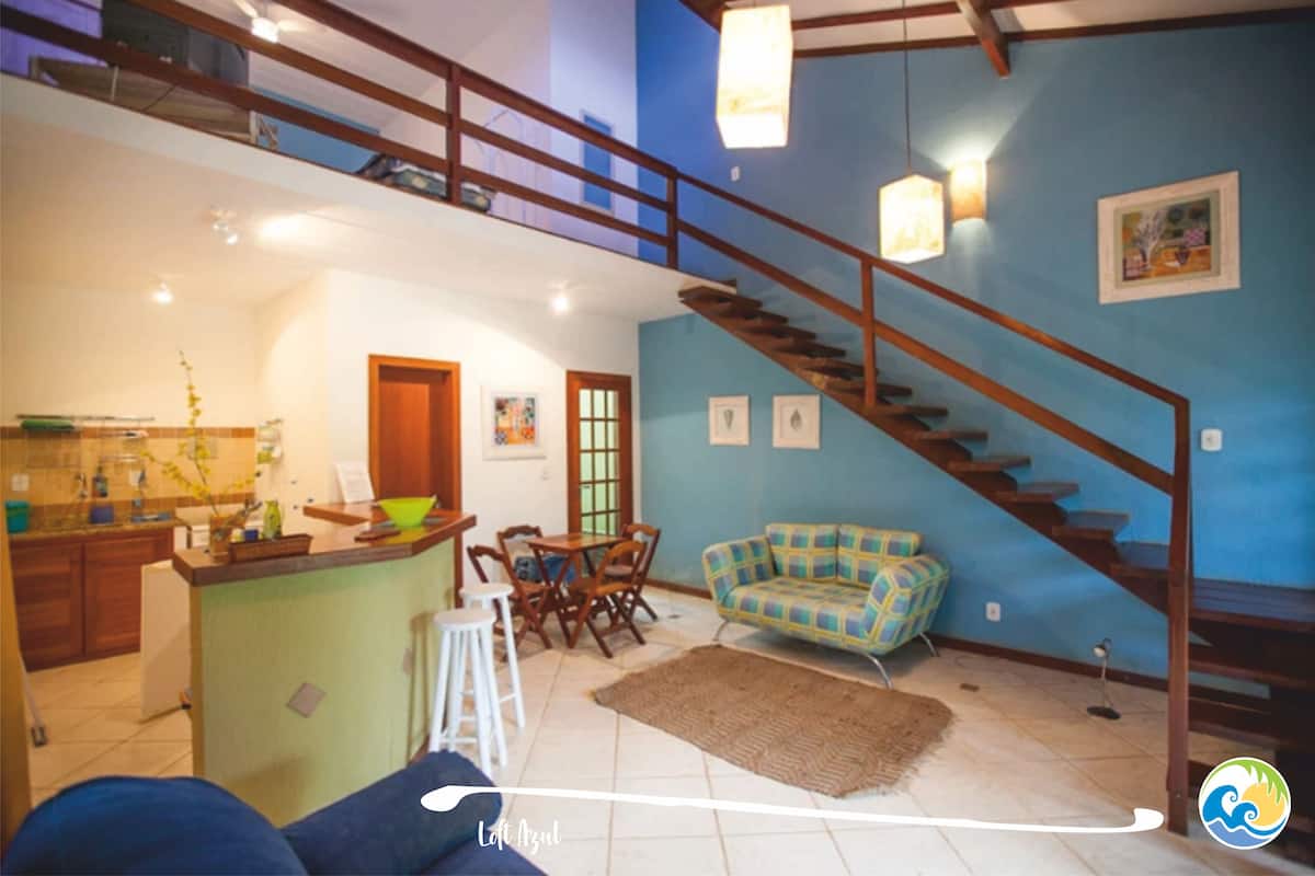 Un grand espace de vie comprenant un escalier, un coin repas et une cuisine.