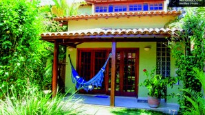 A two-story house with a red-tiled roof, a hammock, and lush greenery. - Residence Solemare Buzios (Búzios)