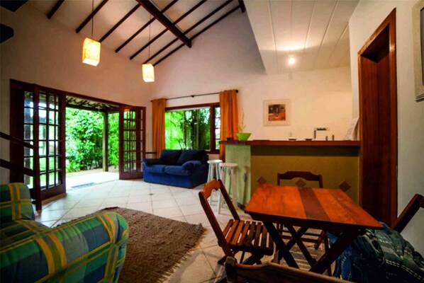 A spacious living area with a sofa, a wooden table, and a blue couch.