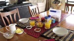 A dining table set with breakfast items, including bowls, a pitcher, and juice glasses. - BigSky Bed and Breakfast (Omarama)