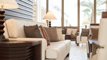 Una sala de estar moderna con un sofá, sillones y lámparas.
