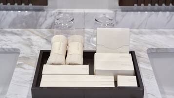 A tray with various toiletries and a razor set on a marble surface.