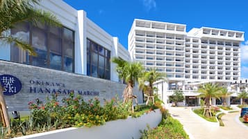A modern hotel with a sign reading "Okinawa Hanasaki Marche".