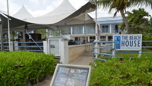 Una casa sulla spiaggia con un'insegna che indica che si tratta di un bar e ristorante.