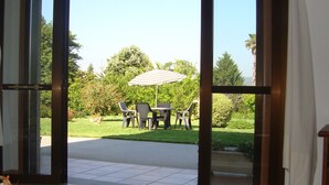 A view of a patio area with a table and chairs, an umbrella, and a lawn. - APARTMENT IN RURAL HOUSE OF SANXENXO, AREA NEAR THE SEA WITH WIFI and FREE PARKING (Sanxenxo)