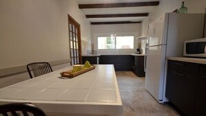 A compact kitchen with a dining table, chairs, a refrigerator, and a microwave. - PROMOTION for May 26 MAY 1 JUNE (Saint-Florent)