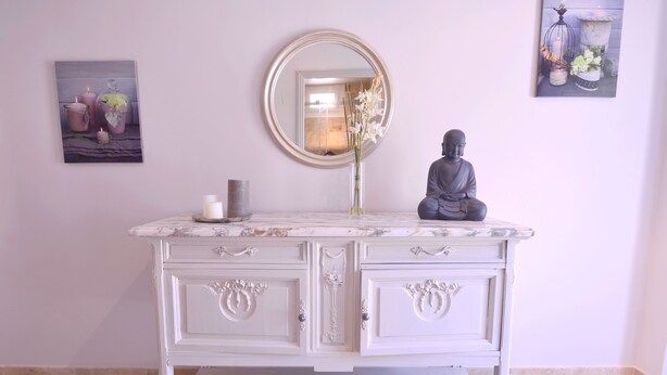 A white vanity with a mirror, candle, and Buddha statue. - PROMOTION for May 26 MAY 1 JUNE (Saint-Florent)