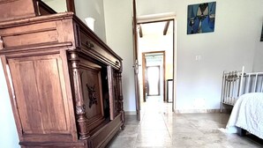 A spacious room with a large wooden cabinet, a radiator, and a tiled floor. - PROMOTION for May 26 MAY 1 JUNE (Saint-Florent)