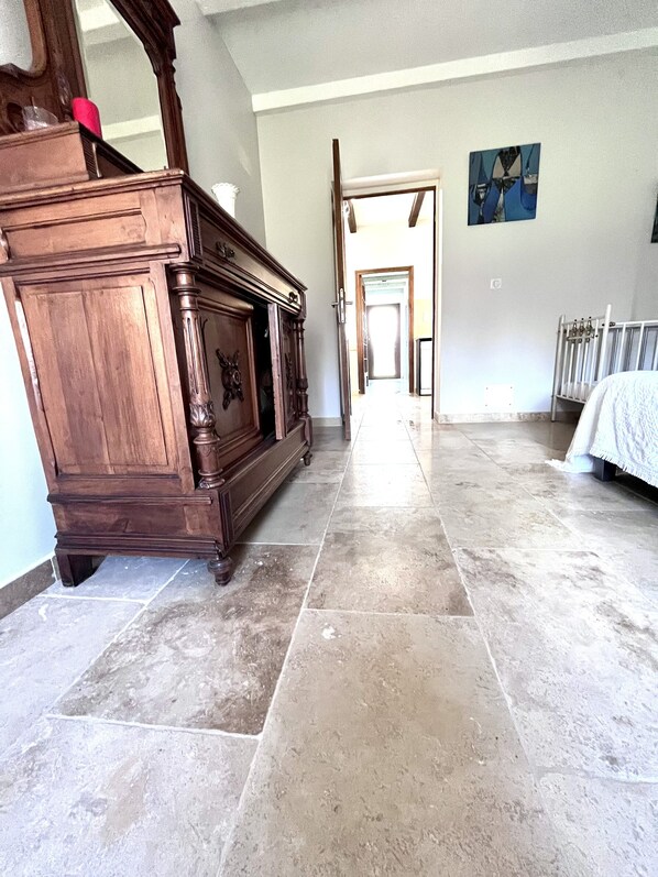 A spacious room with a large wooden cabinet, a radiator, and a tiled floor.