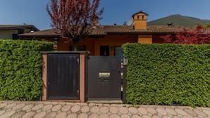 A house with a tiled roof, a chimney, and a gate. - Holiday House - "RESIDENCE LAGO DI ENDINE" (Monasterolo del Castello)