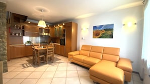 A modern kitchen with wooden cabinets, a dining table, and a sofa. - Holiday House - "RESIDENCE LAGO DI ENDINE" (Monasterolo del Castello)