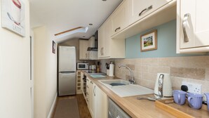 A compact kitchen with a microwave, sink, and a coffee maker. - Charming Original Stone Cottage Close To Beaches and Countryside (Alnwick)