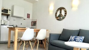 Un espacio habitable compacto con comedor, sofá y una mesita.