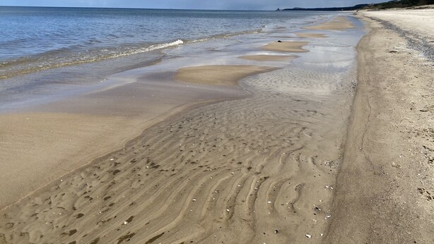 A beach with a clear sky and calm sea.