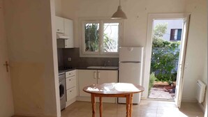 A kitchen with white cabinets, a washing machine, and a table. - semi-detached villa joint ownership of 7 villa located between st raphaél st tropez (Fréjus)