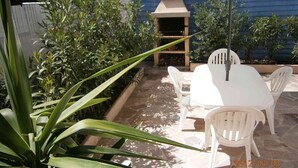A patio area with a table and chairs, a grill, and various plants. - semi-detached villa joint ownership of 7 villa located between st raphaél st tropez (Fréjus)