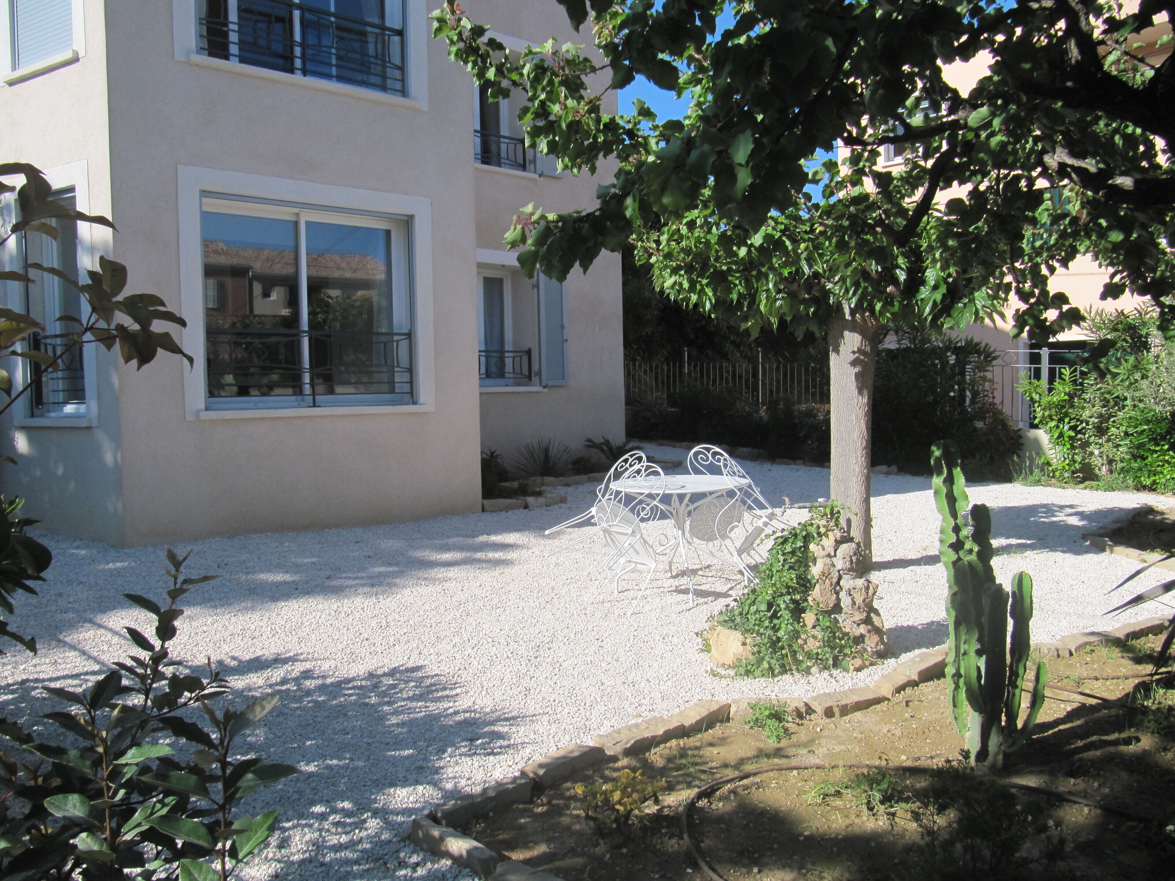 Un bâtiment doté d’un patio, de mobilier d’extérieur et d’un cactus.