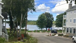 A residential street with houses, a stop sign, and a body of water in the background. - The Sister Bay Getaway: Water View & Downtown! Come enjoy Door County! (Sister Bay)